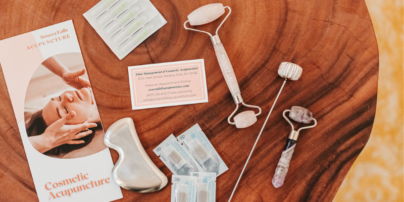 Photo of jade rollers and gua sha tools on a wooden tabletop - these tools exist to help you get healthy, glowing skin at home!