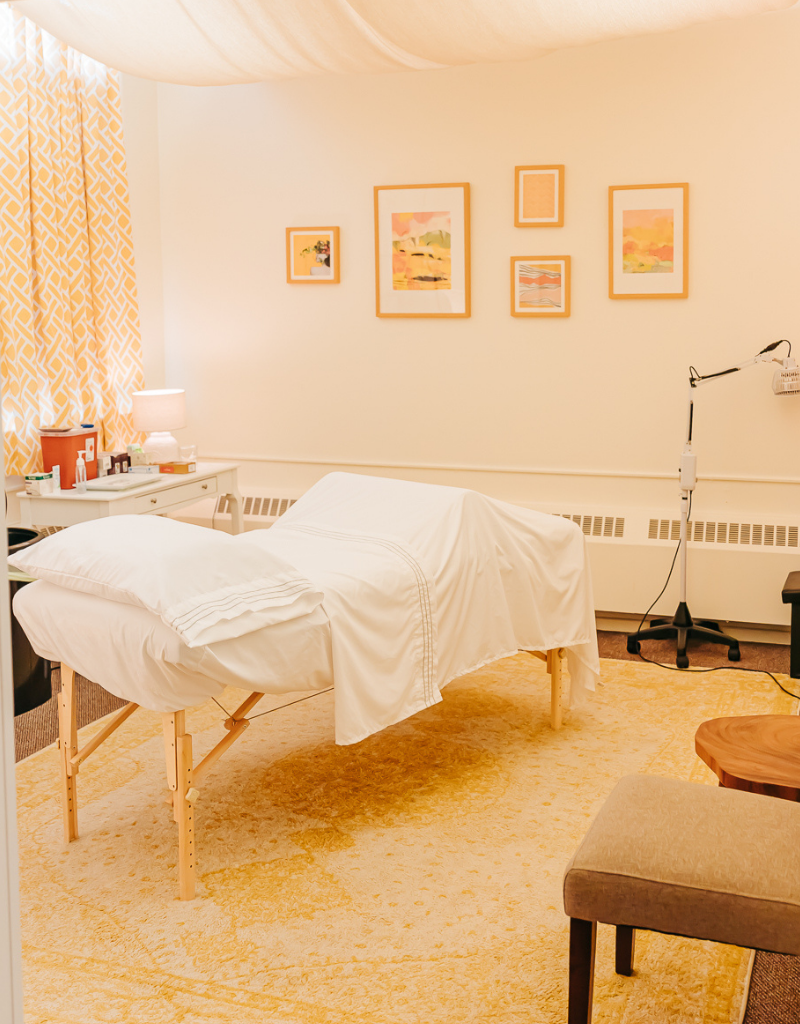 Warm, comfortable acupuncture treatment room in glowing yellow tones at Seneca Falls Acupuncture.
