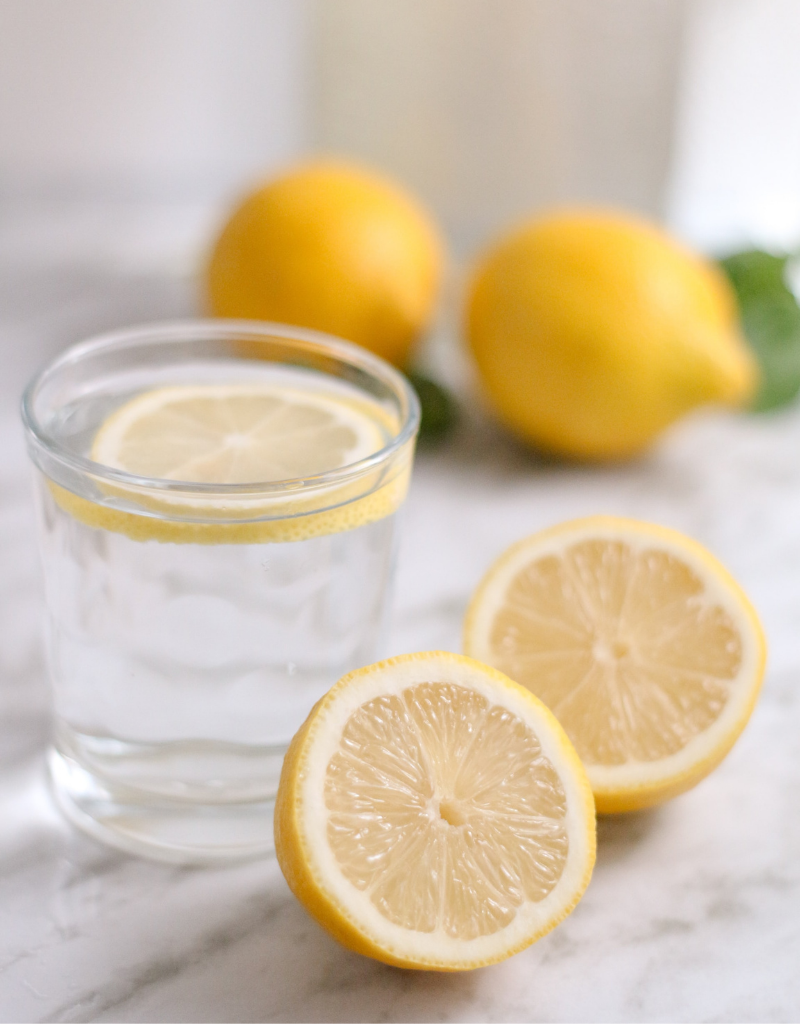 Glass of water with lemon slices in it as part of a diet for youthful skin.