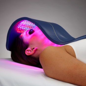 Woman resting with Celluma LED Light over her face and decollete to improve skin health and reduce wrinkles naturally..