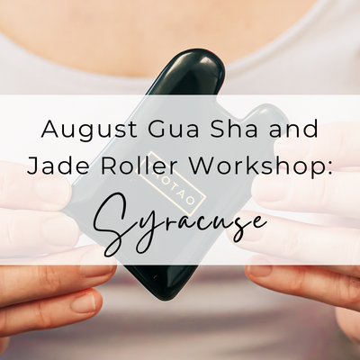 Person holding an obsidian gua sha stone with the text overlay, August Gua Sha and Jade Roller Workshop in Syracuse
