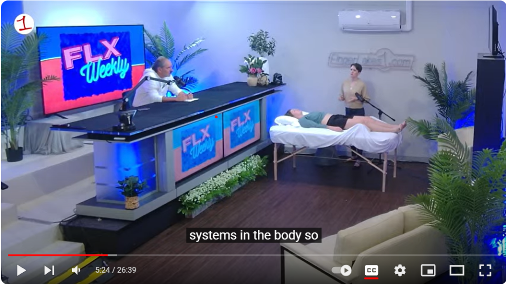 Photo of acupuncturist Michelle Grasek of Seneca Falls Acupuncture in the Finger Lakes 1 studio with the host, Jim, and patient Ashley. Michelle and Jim are speaking while Michelle does a demonstration acupuncture treatment on Ashley for digestion and knee pain.